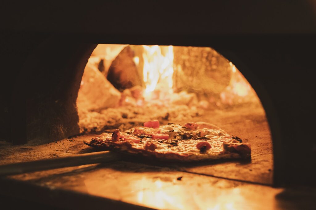 Close up of pizza in a wood-fired oven in a restaurant.