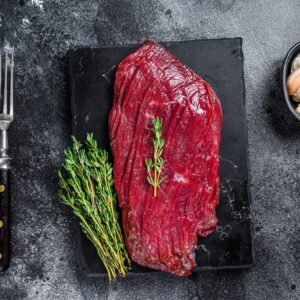 Venison raw steak from wild meat. Black background. Top view